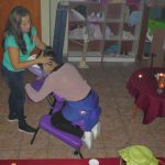 Masajistas realiza un masaje a silla a un profesor empezando por el cuello