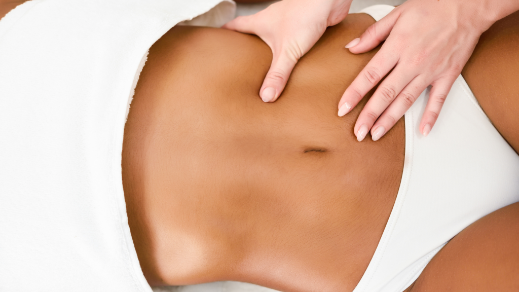 Mujer siendo masajeada en el abdominal