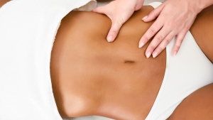 Mujer siendo masajeada en el abdominal