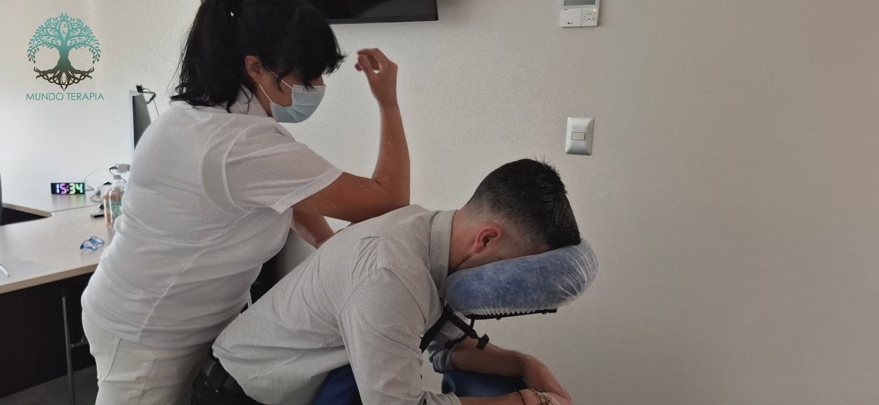 Portada de pagina en la cual una masajista de mundo terapia realiza un masaje en silla